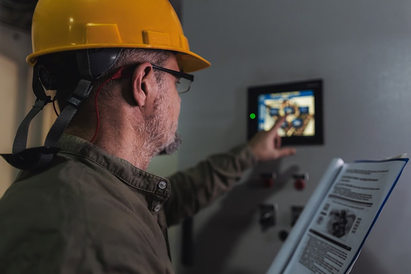 Technician adjusting a commercial thermostat.