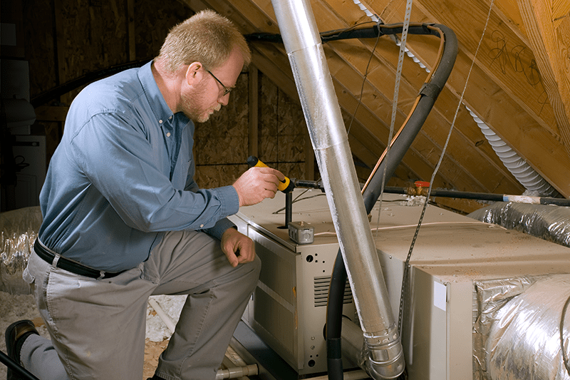 A technician works on a furnace. Furnace Flue Tips.