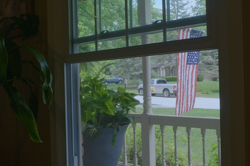 looking out a window of an American suburban home.