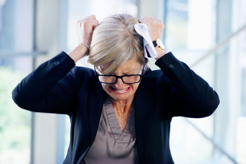 A woman pulling her hair out in frustration, due to her utility bill being high.