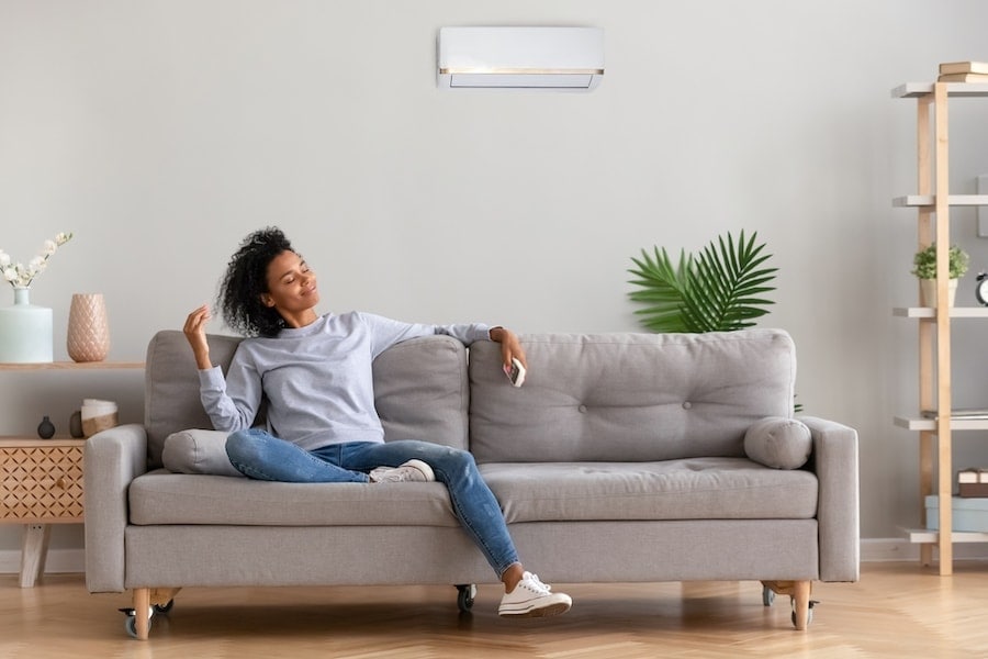 African young relaxed woman sitting on couch breathing fresh air. What Accessories Can Help With My Indoor Air Quality?