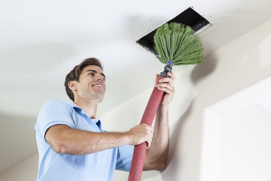 Man Cleaning Air Ducts to help eliminate Mold